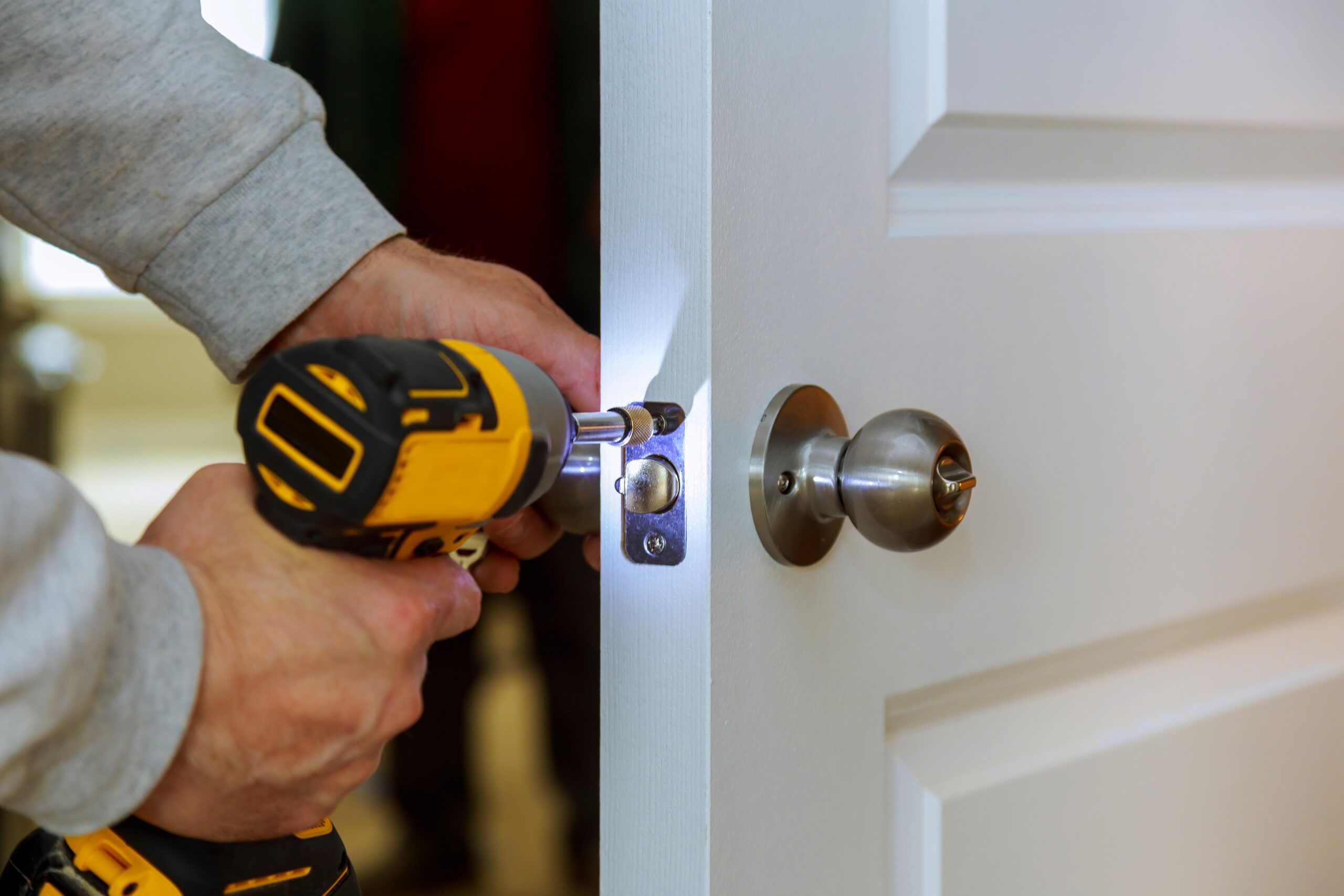 Carpenter Install Door Lock Using Screwdriver At Home installation of locks on the door